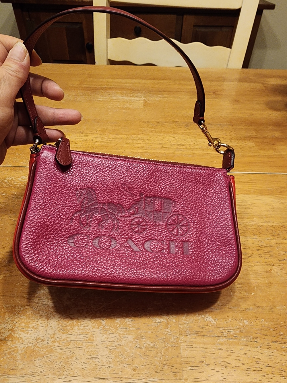 Coach Nolita 19 wristlet in a pink colorblock design featuring an embossed horse